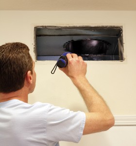 Man Looking into Air Duct